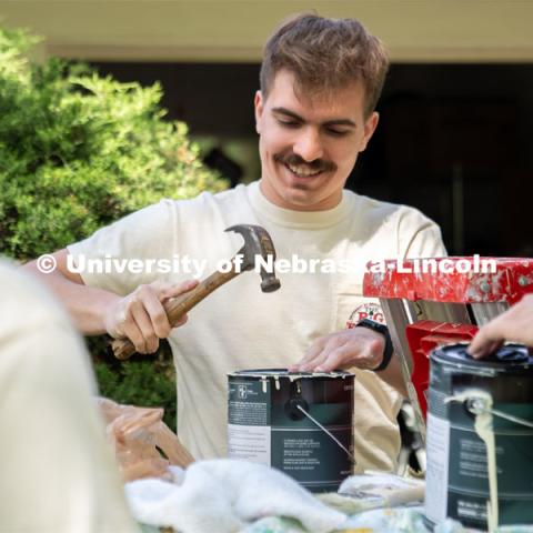 Cole Gustafson of Pi Kappa Alpha replaces the lid of a paint can during the Big Event. May 4, 2024. Photo by Kirk Rangel for University Communication.